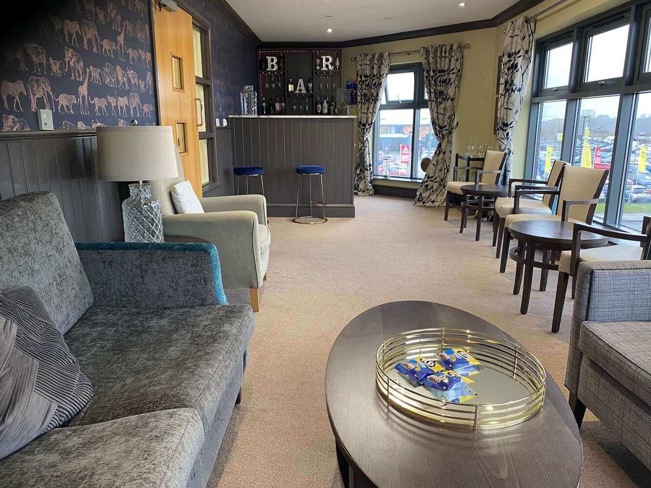 Ebor Court Care Home - Care home lounge with grey sofas and dining tables