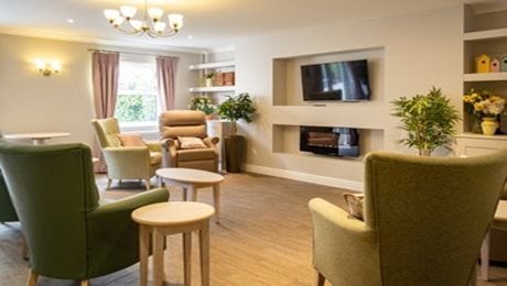 Quarry Hall Care Home - Sitting area, tv, armchairs, shelf