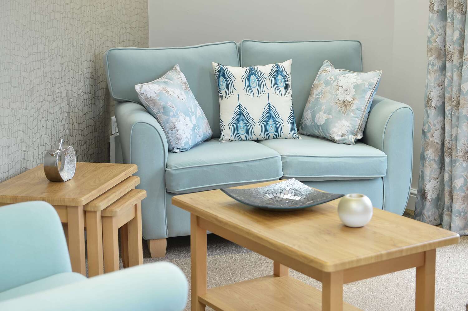 Ebor Court Care Home - Care home lounge with blue sofa and wooden coffee table
