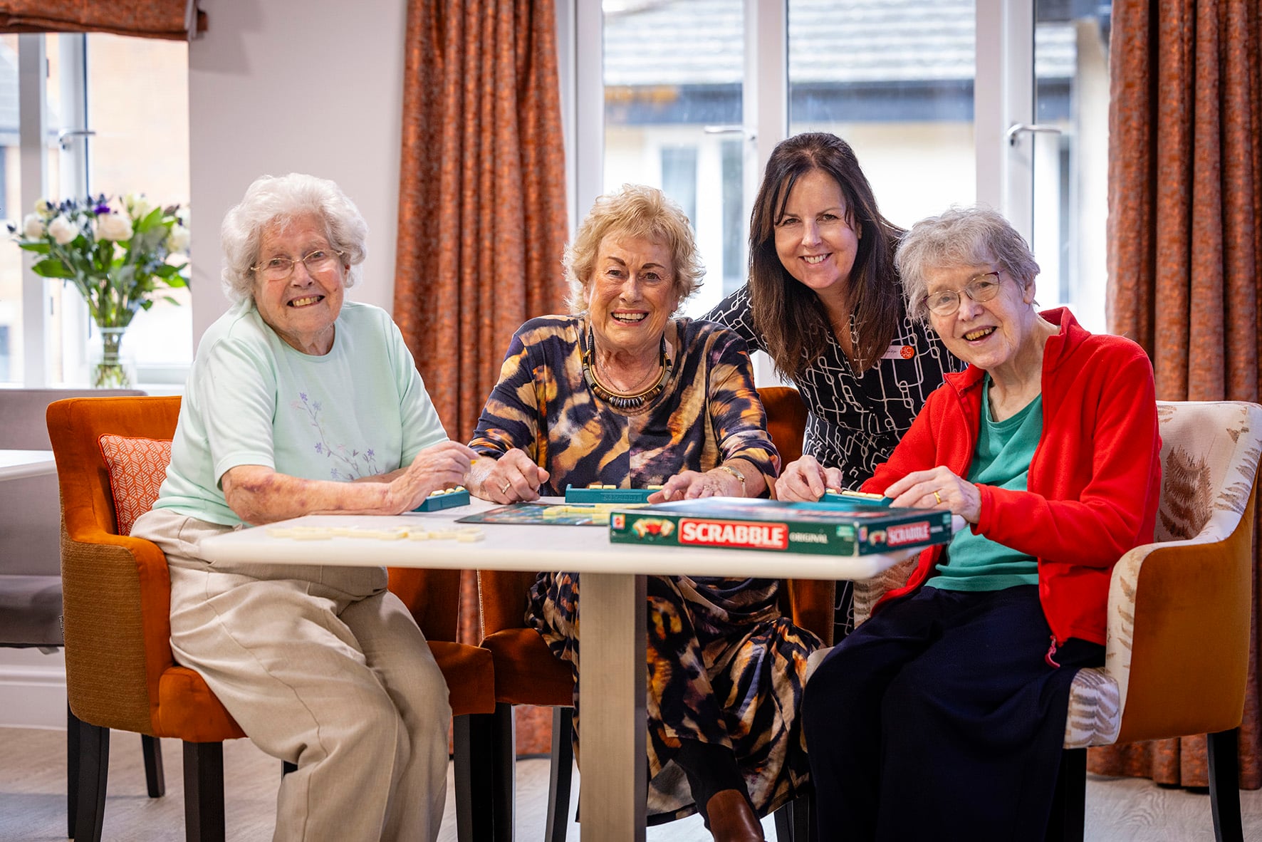 Residents enjoying a game of Scrabble together in a bright lounge