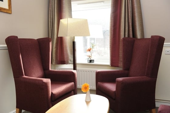 Admirals Reach Care Home - Two dark sitting chairs by the window