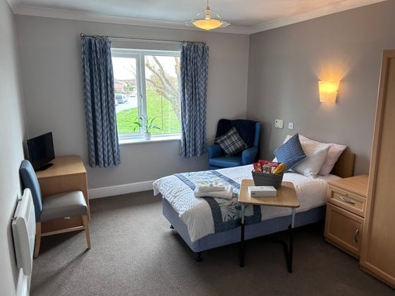 Needham Court Care Home - Senior Living single blue bed