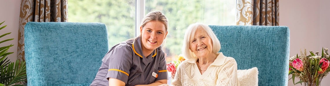 Care home team with resident sitting by the window