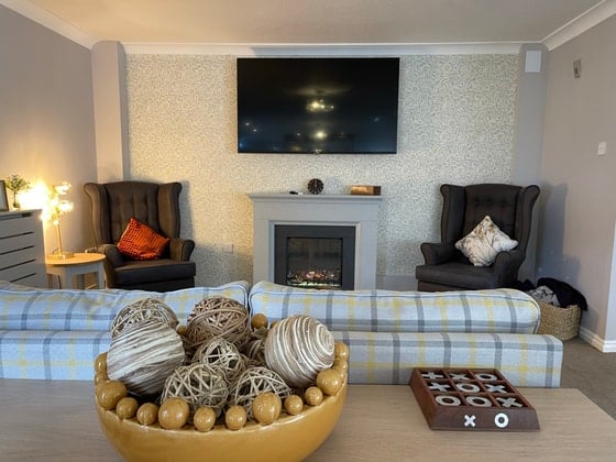 Colton Lodges Care Home - Checkered sofa and fireplace