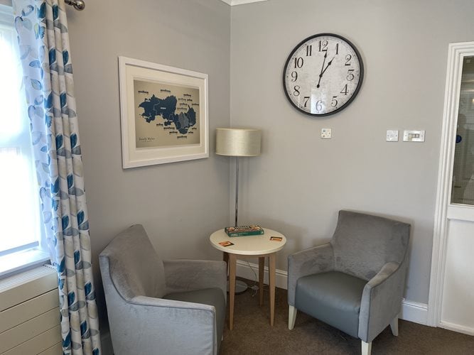 Plas Cwm Carw Care Home - Plas Cwm Carw sitting area with chairs and a clock