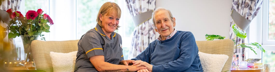 Carehome resident sitting with carer