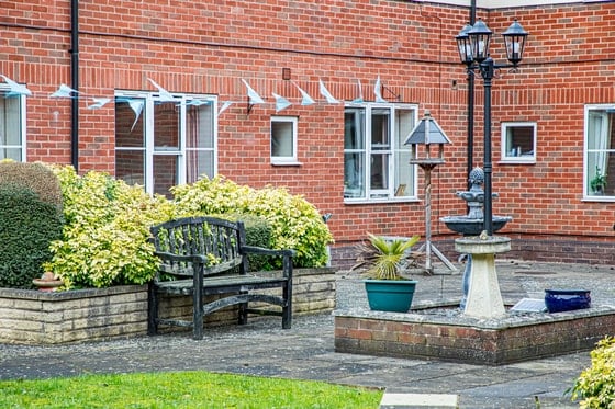 Springwater Lodge Care Home - Outdoor area with plants, lamppost and bench