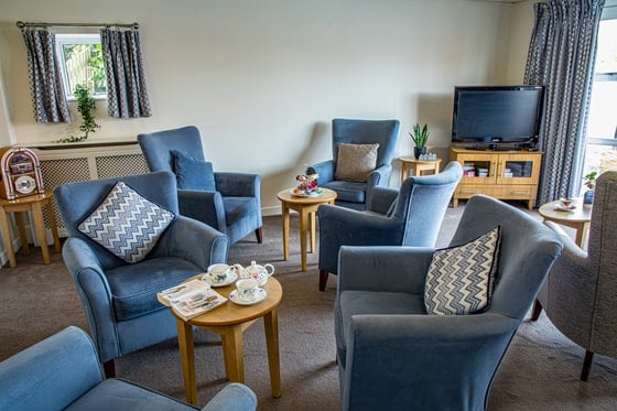 Springwater Lodge Care Home - Comfortable blue chairs in tv room