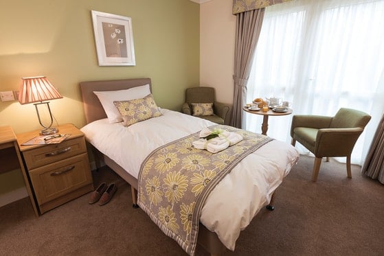 The Oakes Care Home - White single bed and green wall