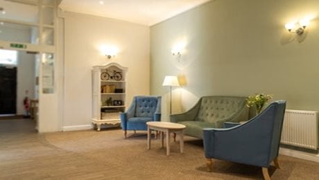 Quarry Hall Care Home - Sitting area, sofa, armchairs, bookshelf, modern