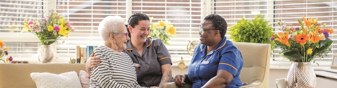 Colton lodges care home staff and resident sat by the window